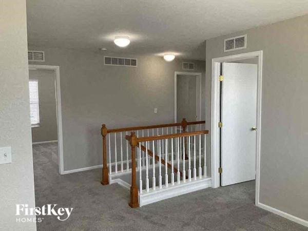 an empty room with a staircase and a white door