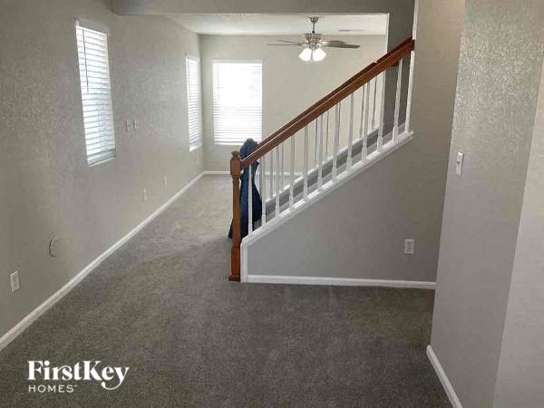 a living room with a staircase and a ceiling fan