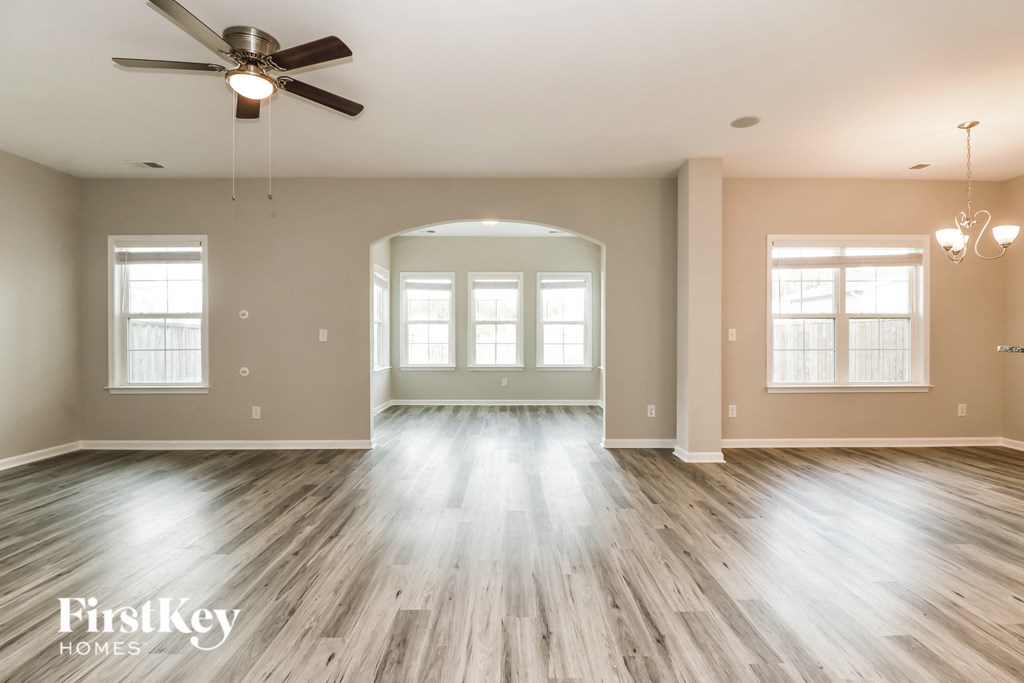 the living room of an empty house with a ceiling fan