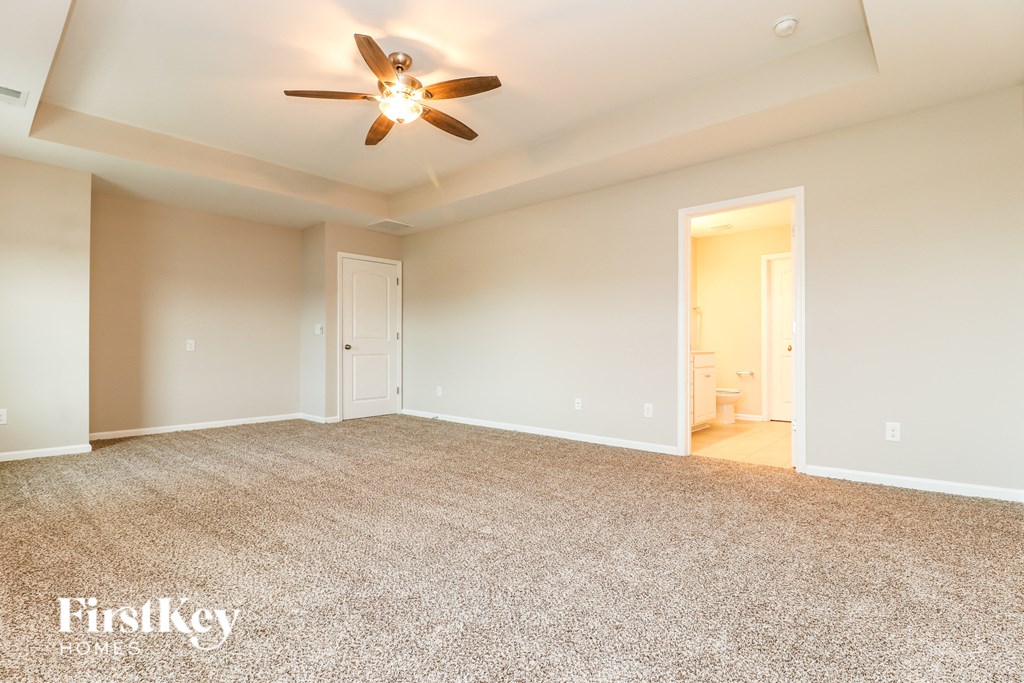 an empty living room with a ceiling fan