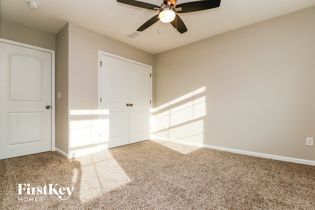 the master bedroom has a ceiling fan and carpeted flooring