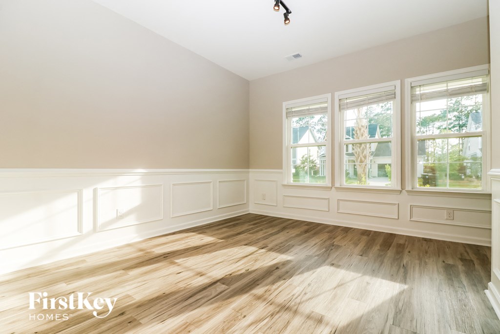 an empty living room with wood floors and white walls