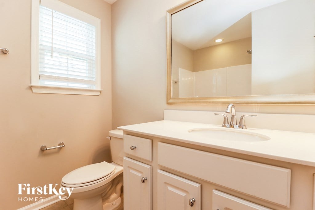 a bathroom with a toilet and a sink and a mirror
