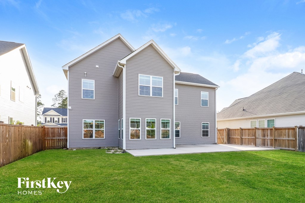 a gray house with a yard and a wooden fence
