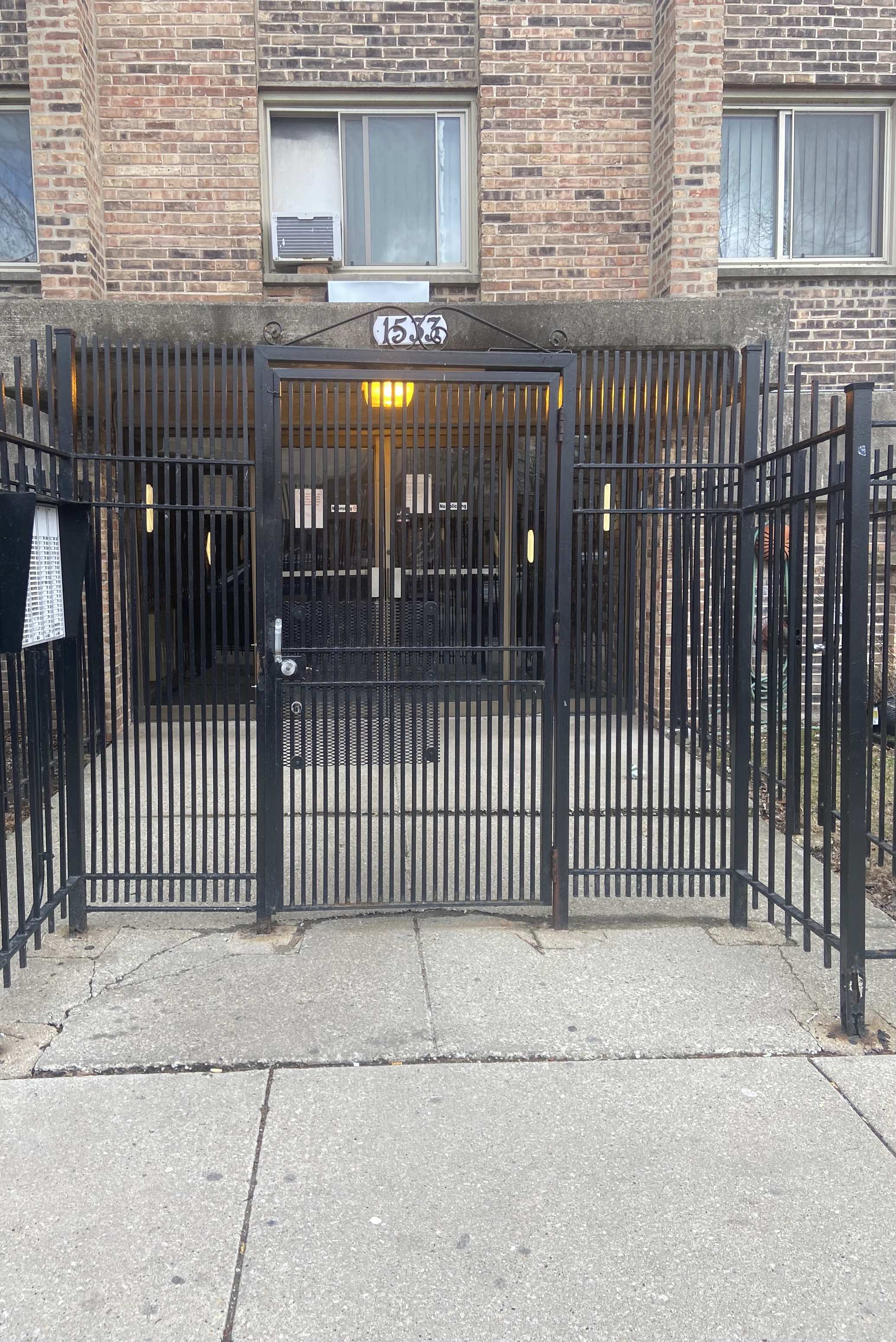 a black wrought iron gate in front of a brick building
