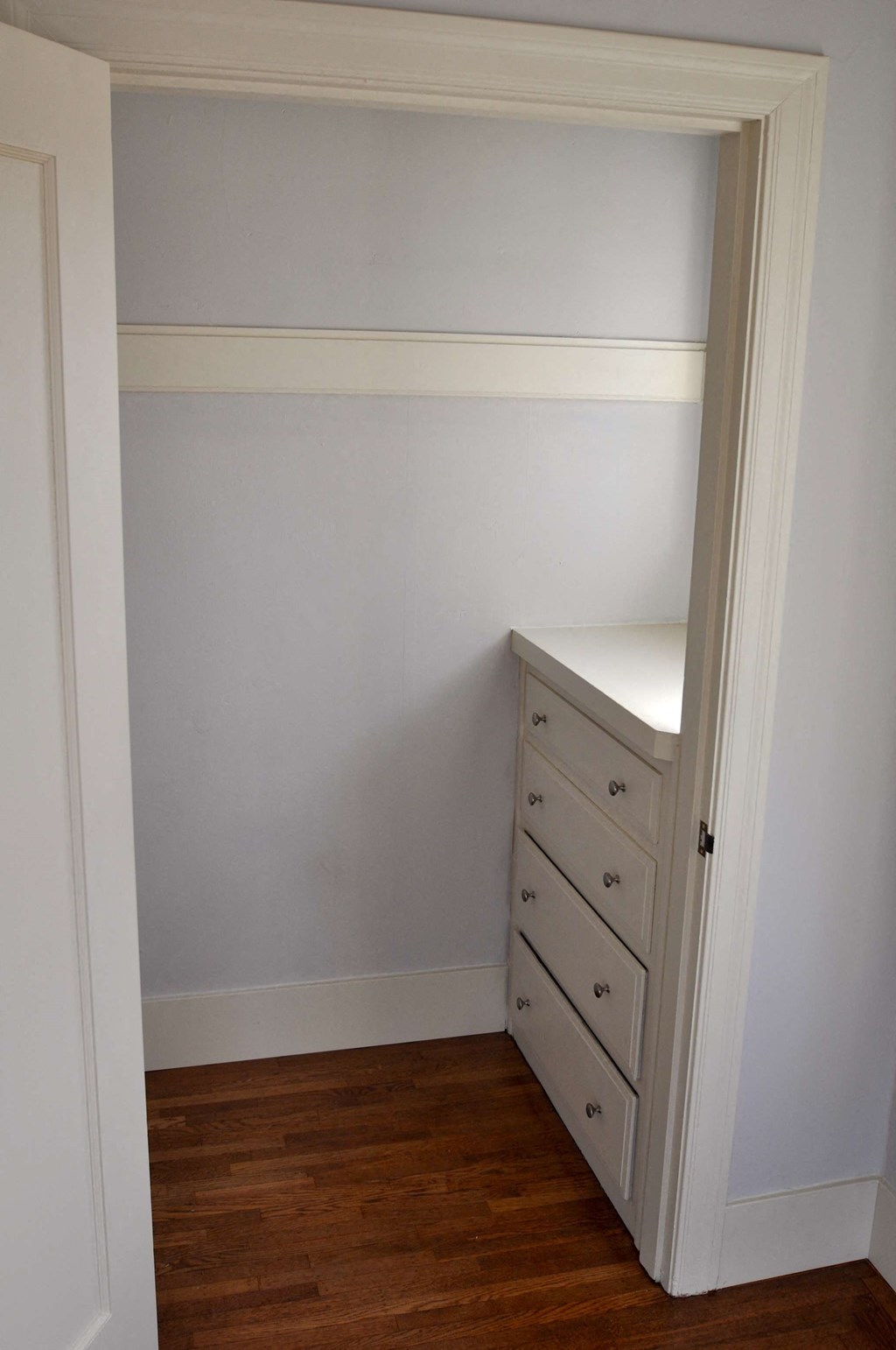 a small room with a desk and a dresser
