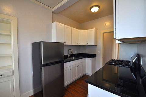 a kitchen with white cabinets and a stainless steel refrigerator