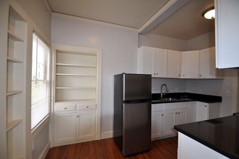 a kitchen with white cabinets and a stainless steel refrigerator