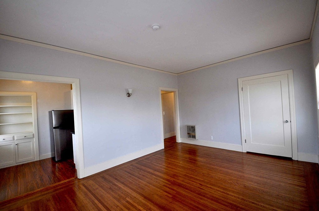 a empty living room with wood floors and white walls