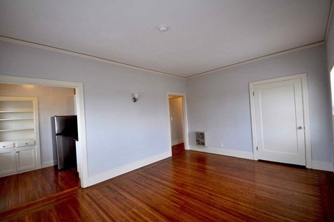 a empty living room with wood floors and white walls