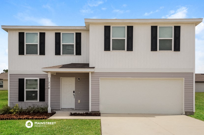 a white house with a sidewalk in front of it