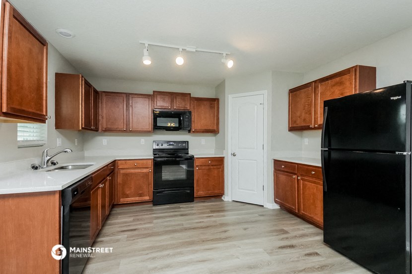 a kitchen with black appliances and wooden cabinets