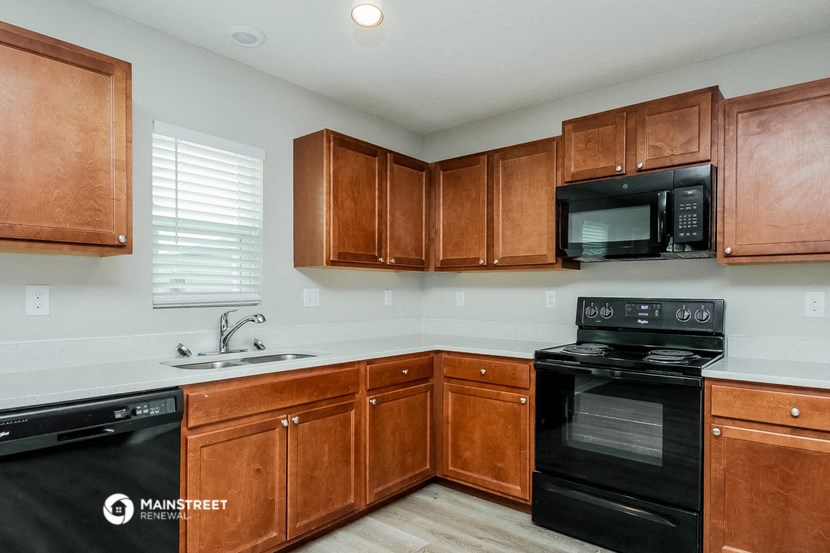 a kitchen with black appliances and wooden cabinets