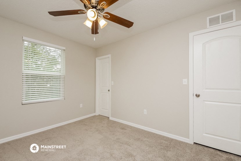 the spacious bedroom has a ceiling fan and a closet