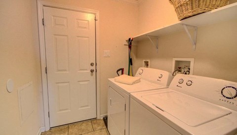 a washer and dryer in a laundry room with a white door