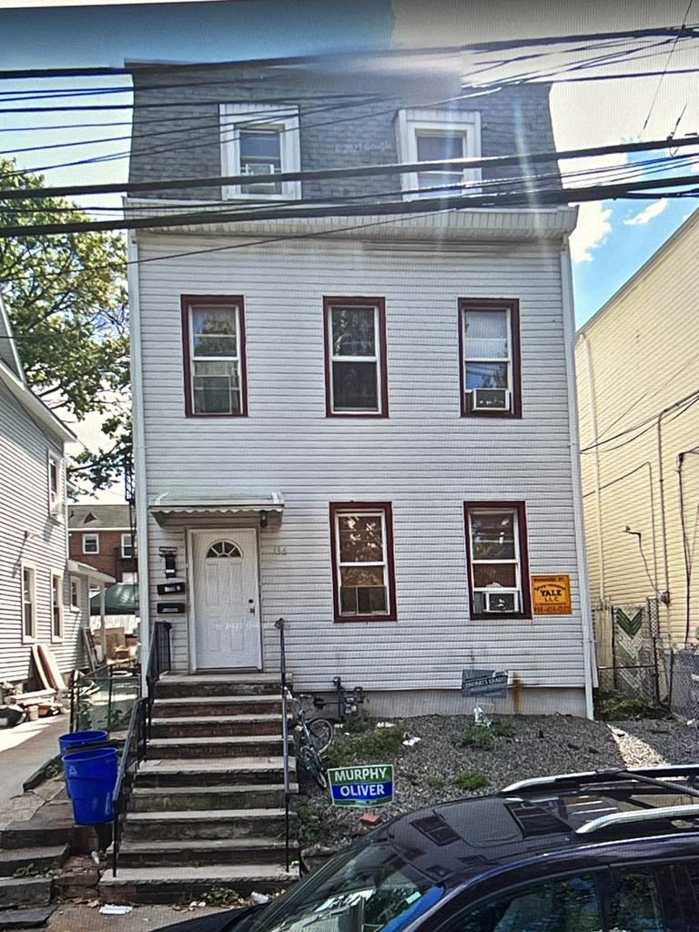 the front of a white house with stairs