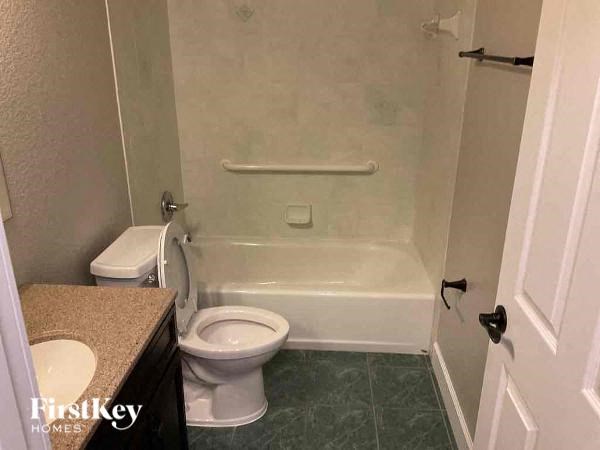 A white toilet is next to a bathtub in a bathroom.