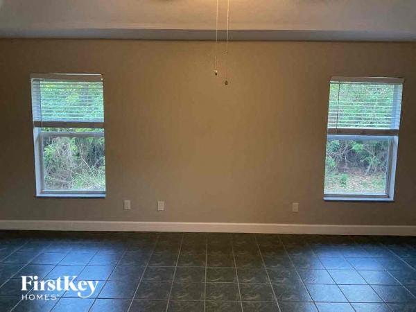 A room with two windows and a FirstKey Homes logo on the floor.