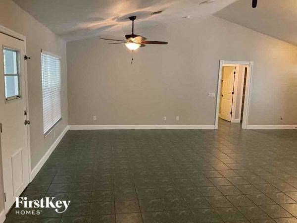 A room with a ceiling fan and tile flooring.