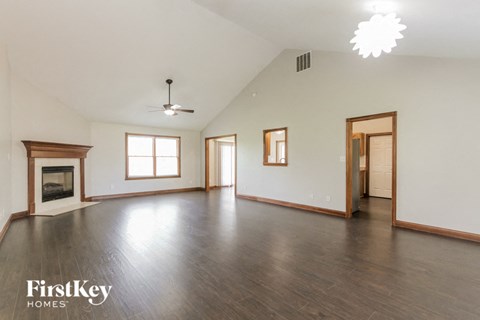 an empty living room with wood floors and a fireplace