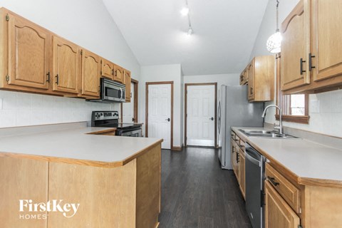 a kitchen with wooden cabinets and a white counter top and a sink