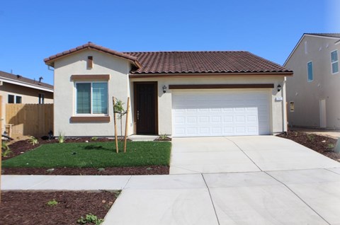 A house with a brown roof and a white garage door.