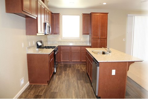 A kitchen with brown cabinets and a stainless steel dishwasher.