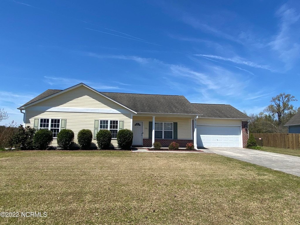 A house with a garage and a driveway in front.