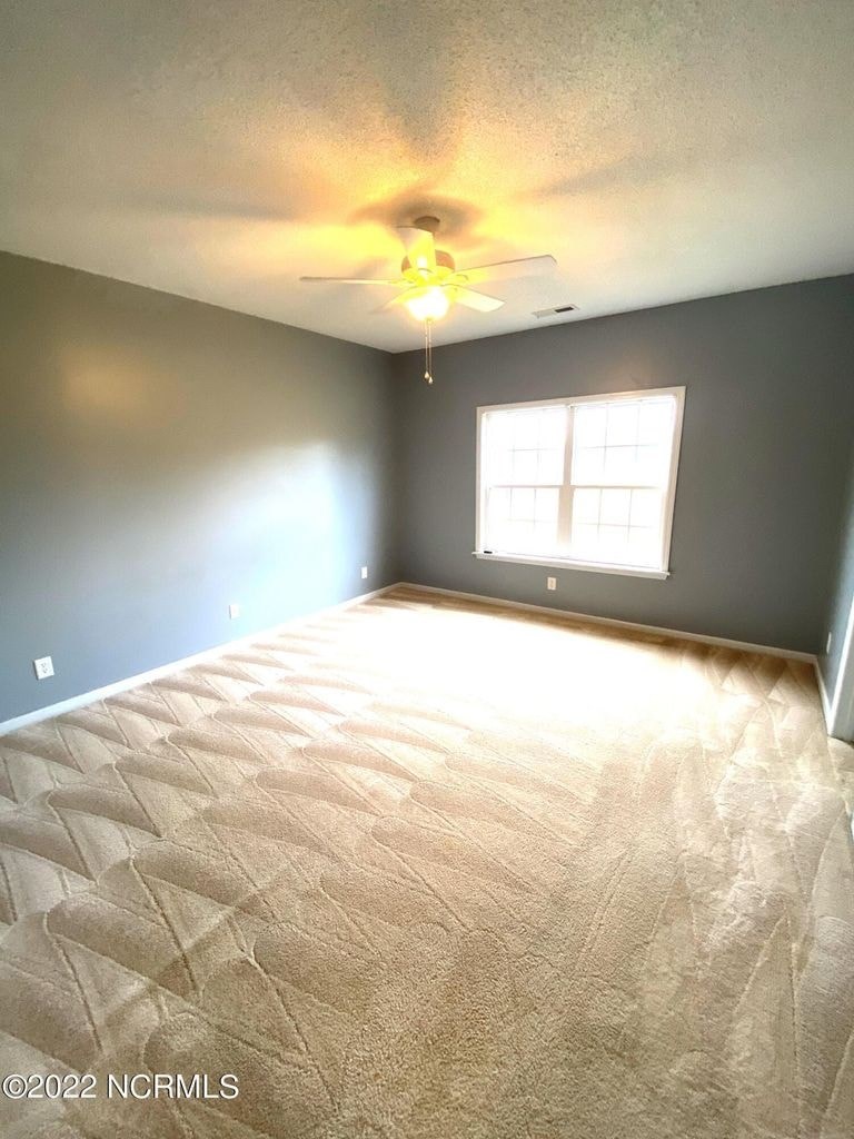 A room with a ceiling fan and a window.