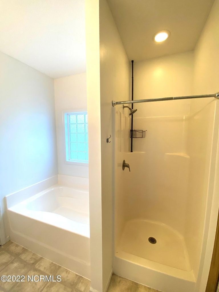A white bathroom with a tub and shower.