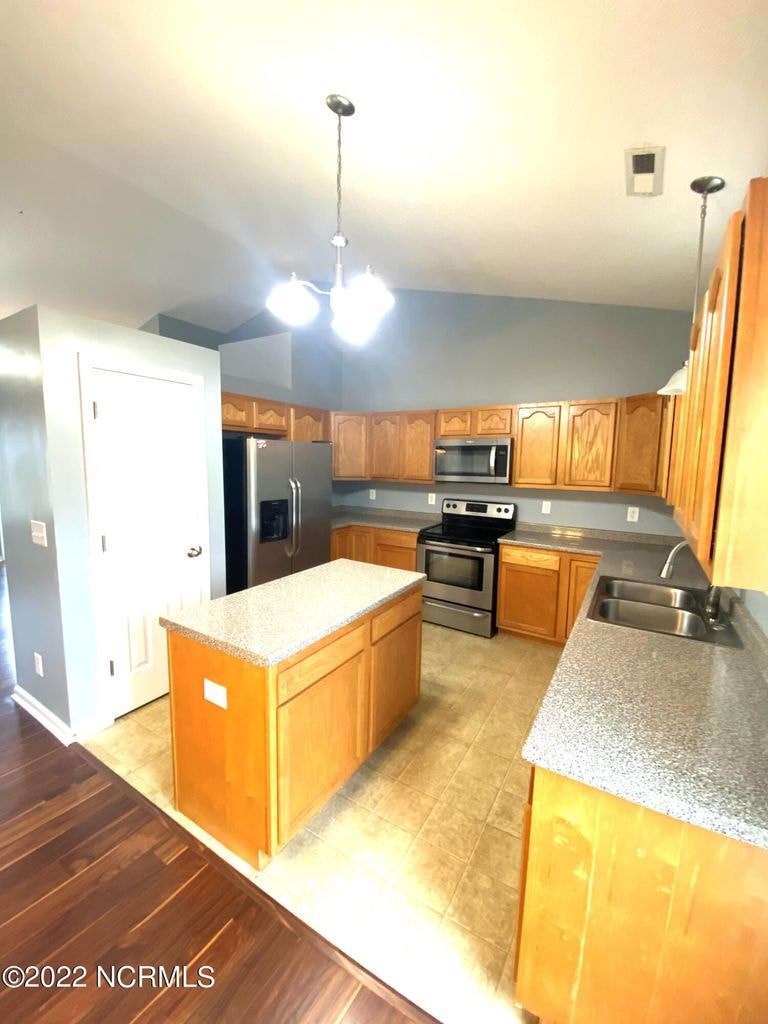 A kitchen with wooden cabinets and a white island.