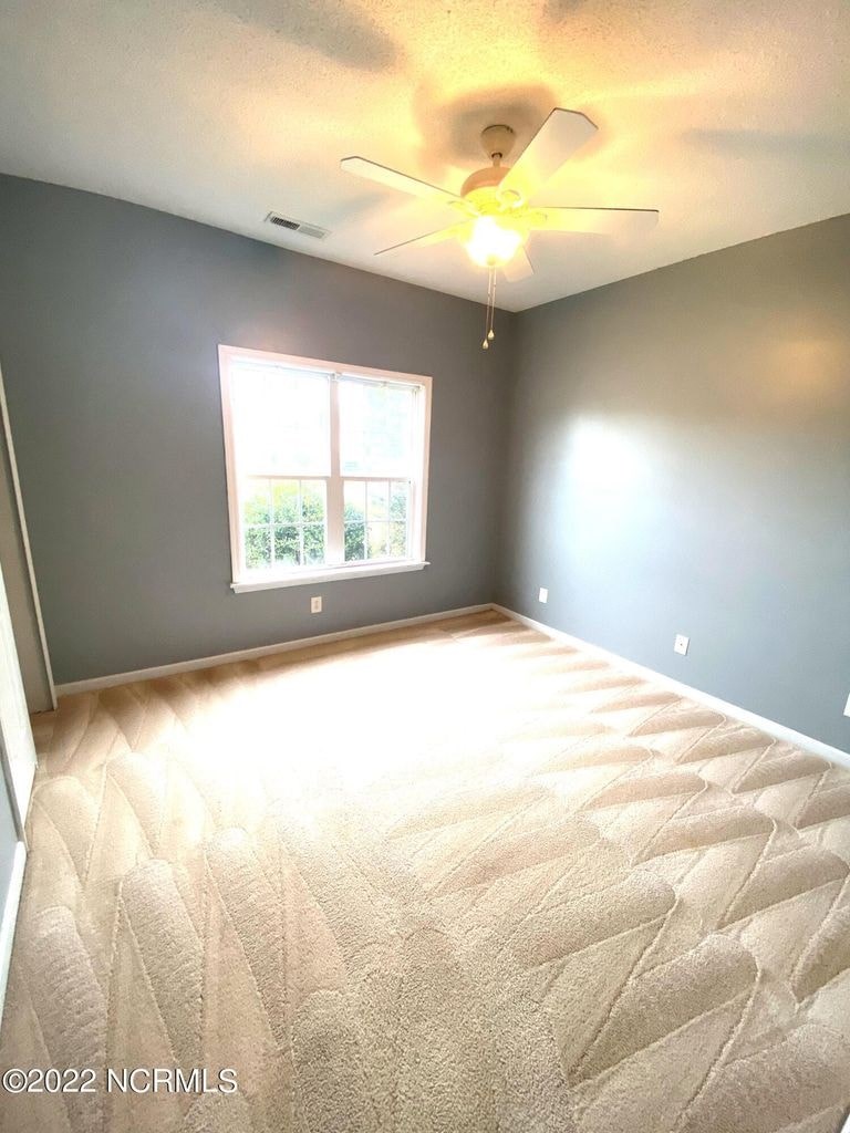 A room with a ceiling fan and a window.