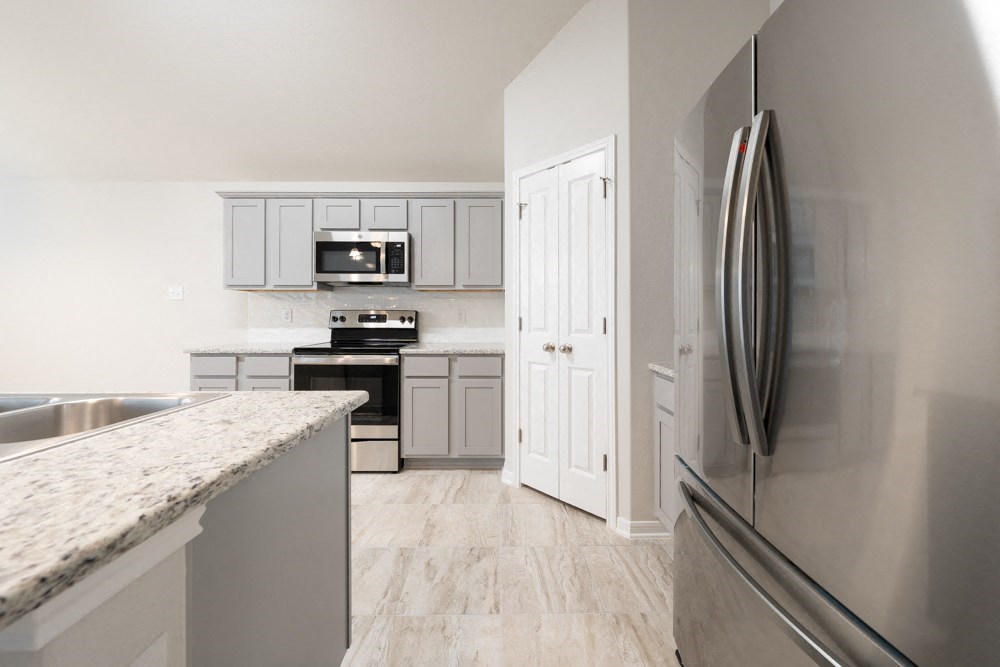 a kitchen with stainless steel appliances and white cabinets