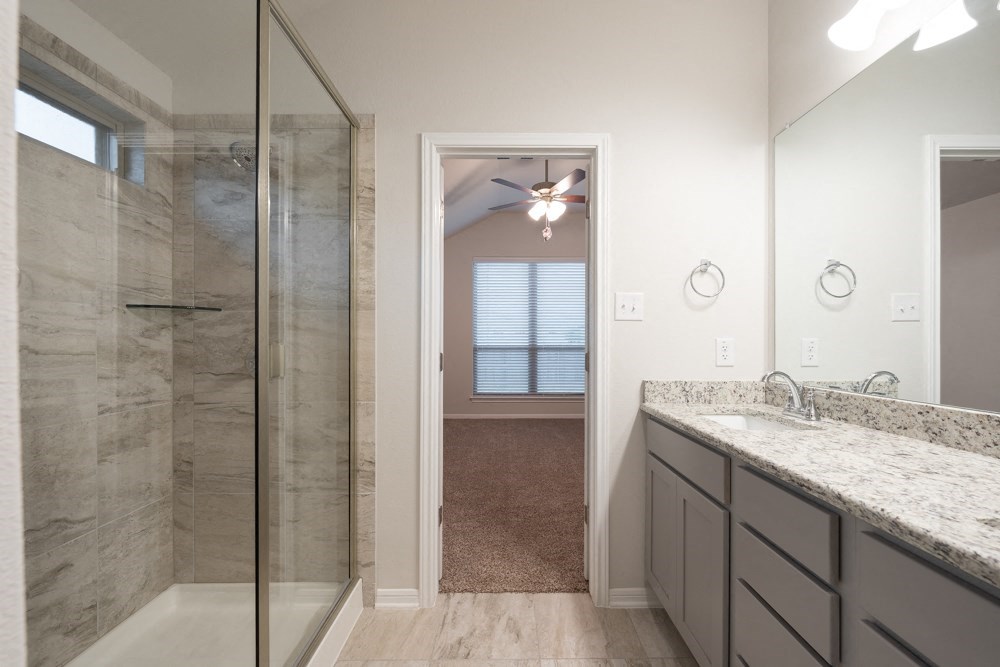 a bathroom with a shower and a sink and a mirror