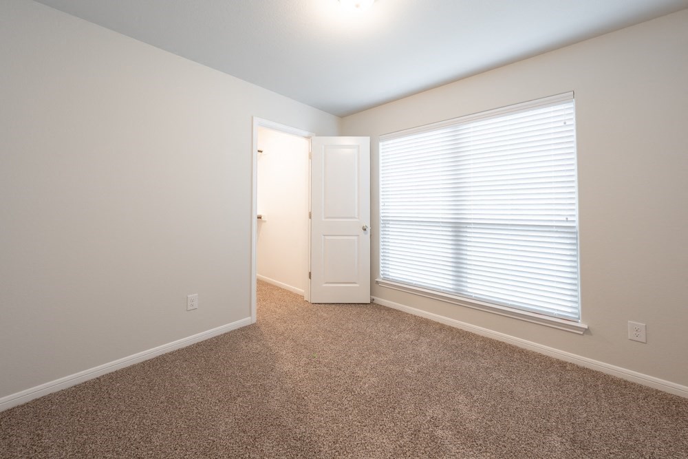 a bedroom with a large window and a door to a closet