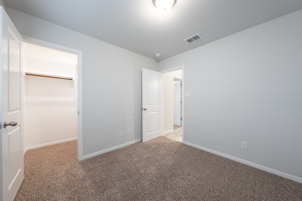 a bedroom with a closet and a door to a bathroom
