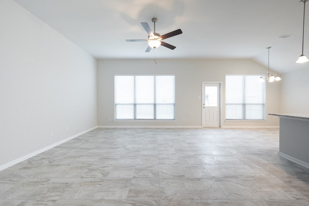 an empty living room with a ceiling fan and a window