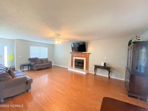 A living room with a grey couch and a fireplace.