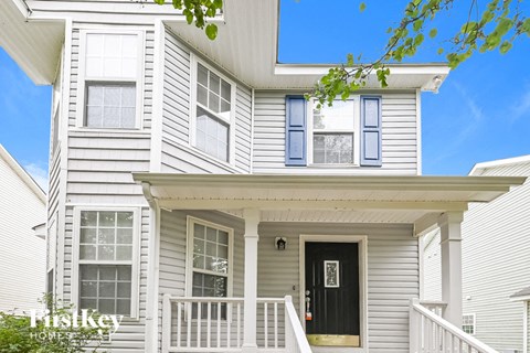 a white house with a black door and a porch