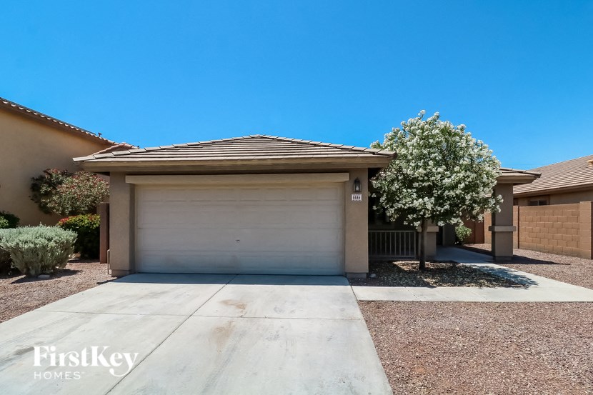 A house with a garage door and a tree in front.