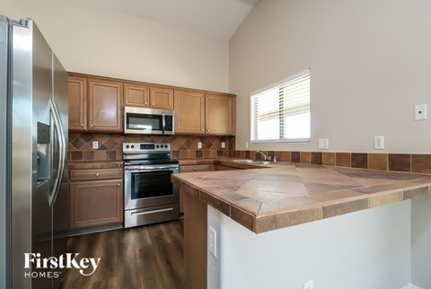 A kitchen with wooden cabinets and a stone countertop.
