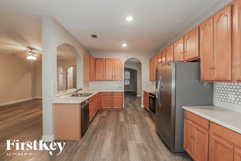 a kitchen with wooden cabinets and a stainless steel refrigerator
