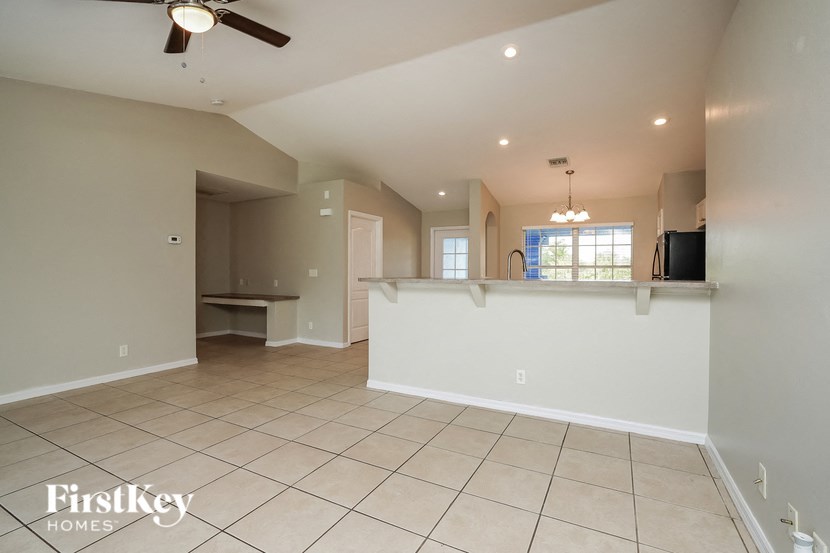 an open kitchen and living room with tiled flooring