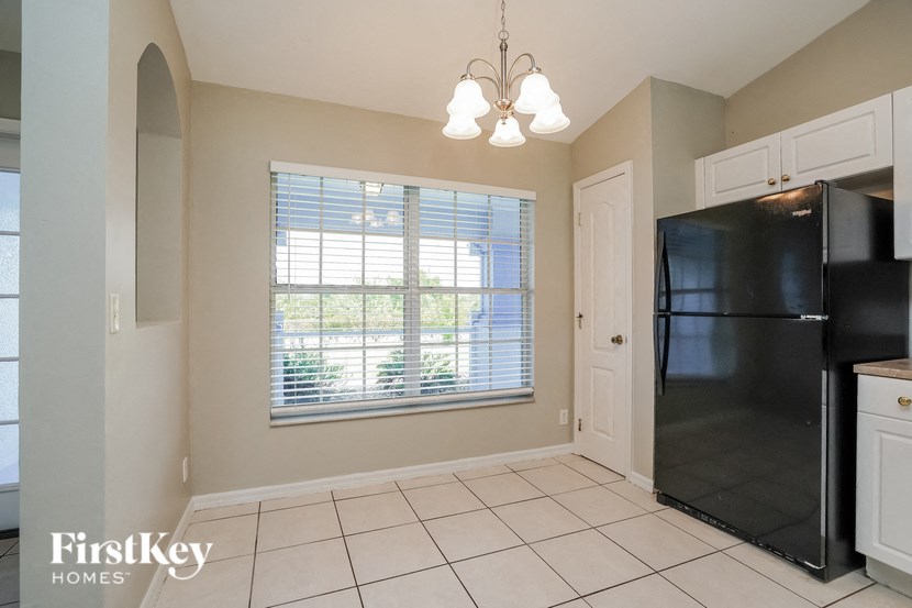 a kitchen with a large window and a black refrigerator