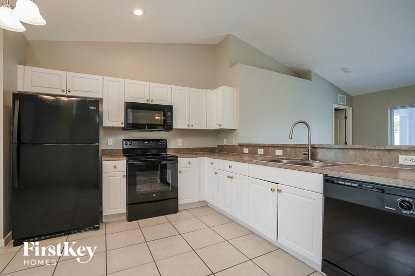 a large kitchen with black appliances and white cabinets
