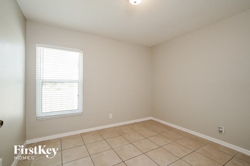 an empty room with a window and a tiled floor