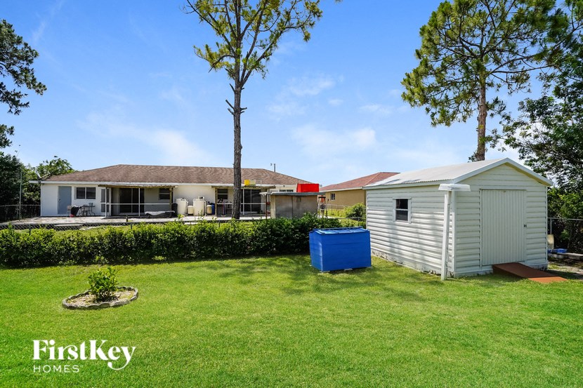 a backyard with a shed and a pool and a house