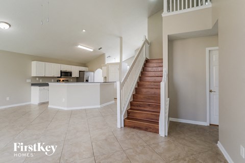 A spacious kitchen with a staircase leading to the upper floor.
