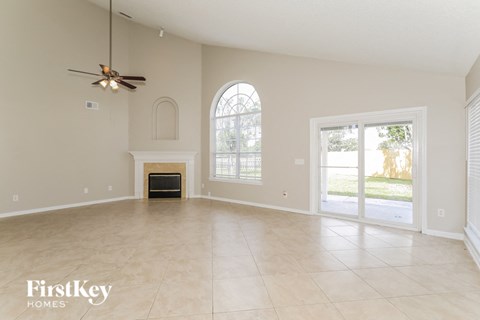 A spacious room with a fireplace and a ceiling fan.
