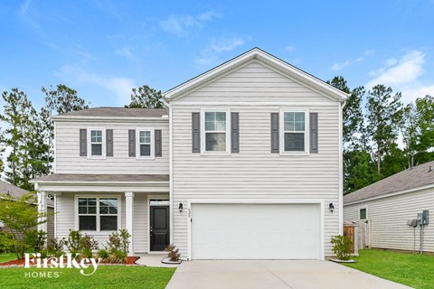 a white house with white siding and a driveway